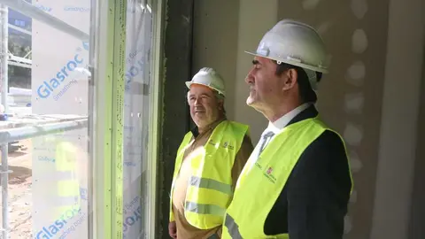 Alcalde y consejro en una de las estancias de la vivienda