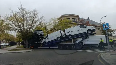 un camión portacoches queda encajado entre árboles_2