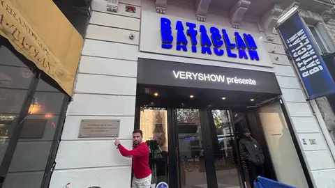 Emmanuel Fernáqndez en el Bataclan, muestra la placa en homenaje a las 130 víctimas del atentado yihadista