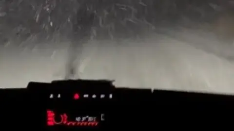 Autob&uacute;s escolar circulando por una v&iacute;a con nieve