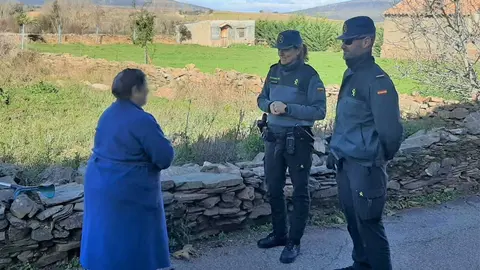 Pareja de la Guardia Civil conversa con una mujer mayor