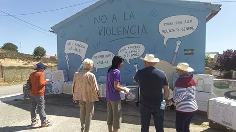 Vecinos con Raquel Pascual en la exposici&oacute;n itinerante sobre el mural contra la violencia de g&eacute;nero