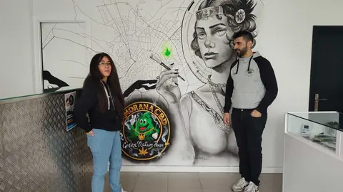 Pedro y Fany junto al mural que luce en la tienda de la Plaza de Cristo Rey
