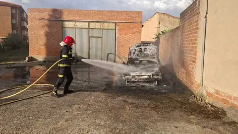 Un bombero trabaja en la extinci&oacute;n del incendio declarado en un veh&iacute;culo en Villalpando