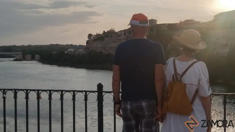Turistas contemplan la ciudad desde el Puente de Piedra