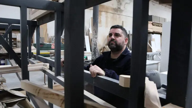 El tallista zamorano José Ángel Domínguez Ramos junto a la estructura que esconderá la nueva mesa de la virgen Dolorosa. Fotografía: Marcos Vicente