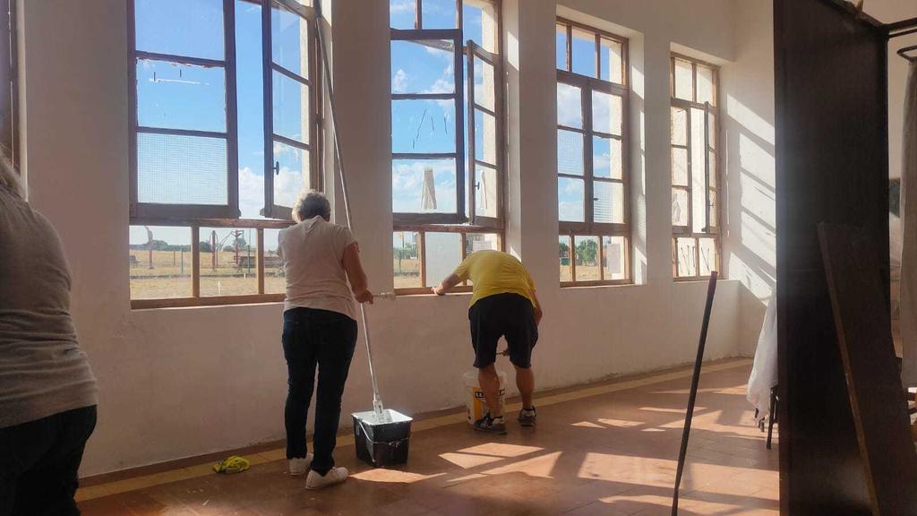 Voluntarios pintando y limpiando las antiguas escuelas. Fotografía: CEDIDA