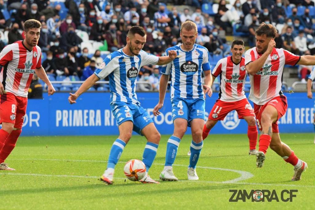 El jugador del Deportivo La Coruña, Lapeña despeja un balón rodeado de jugadores rojiblancos. | FOTO: Zamora CF