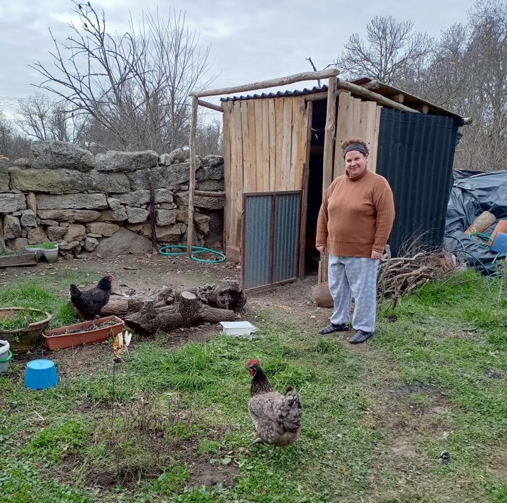 Apola con sus gallinas en el patio trasero de la casa