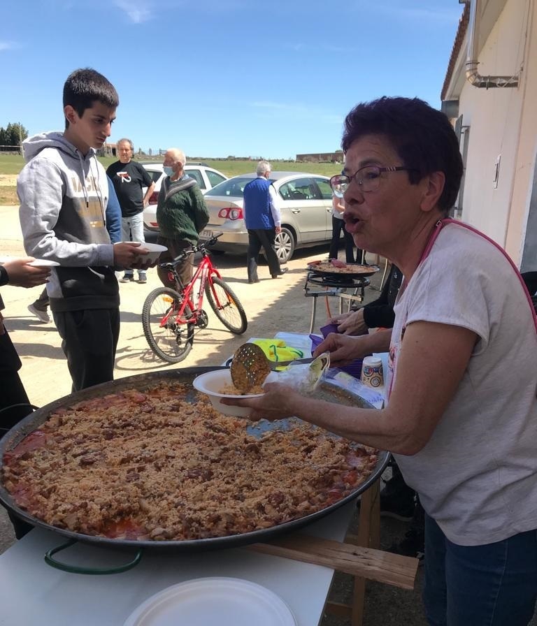 Dominga López Domínguez, presidenta de la asociación cultural de Videmala, sirviendo raciones de arroz a la zamorana. Fotografía: CEDIDA