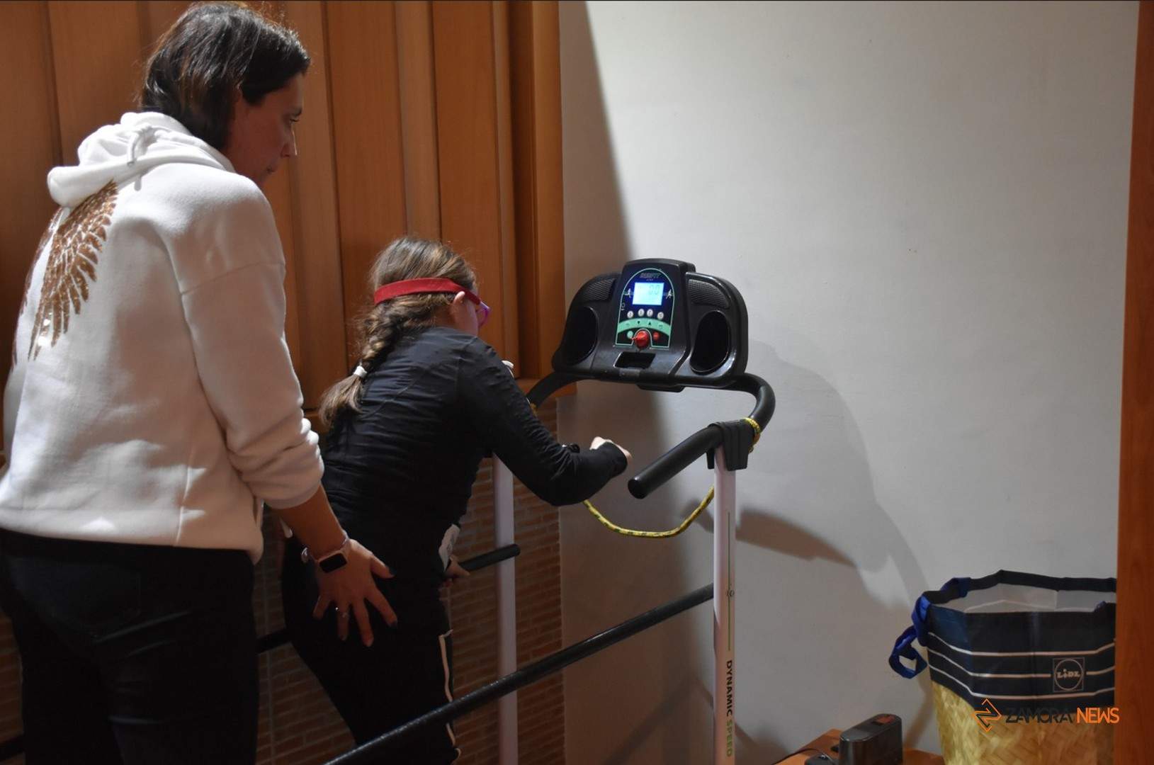 Yaiza y su madre Isabel durante una de las sesiones de estimulación sobre la cinta de correr en su casa de Torrefrades. Fotografía: Aroa Colmenero