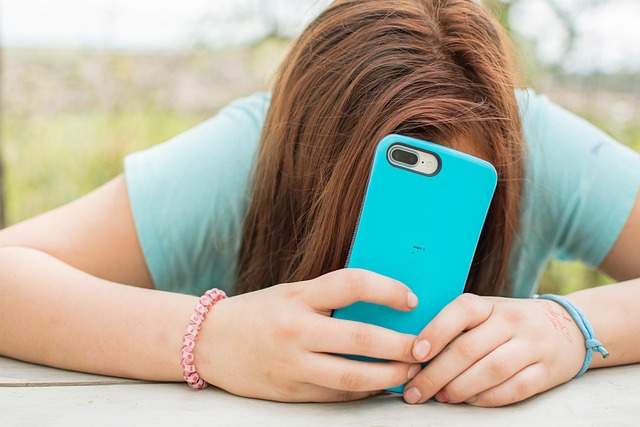 Una adolescente usa su teléfono móvil. Imagen de archivo