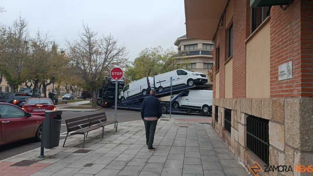 un camión portacoches queda encajado entre árboles_3