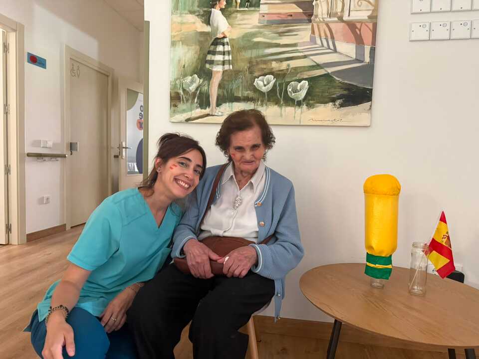 Una trabajadora del centro con una residente